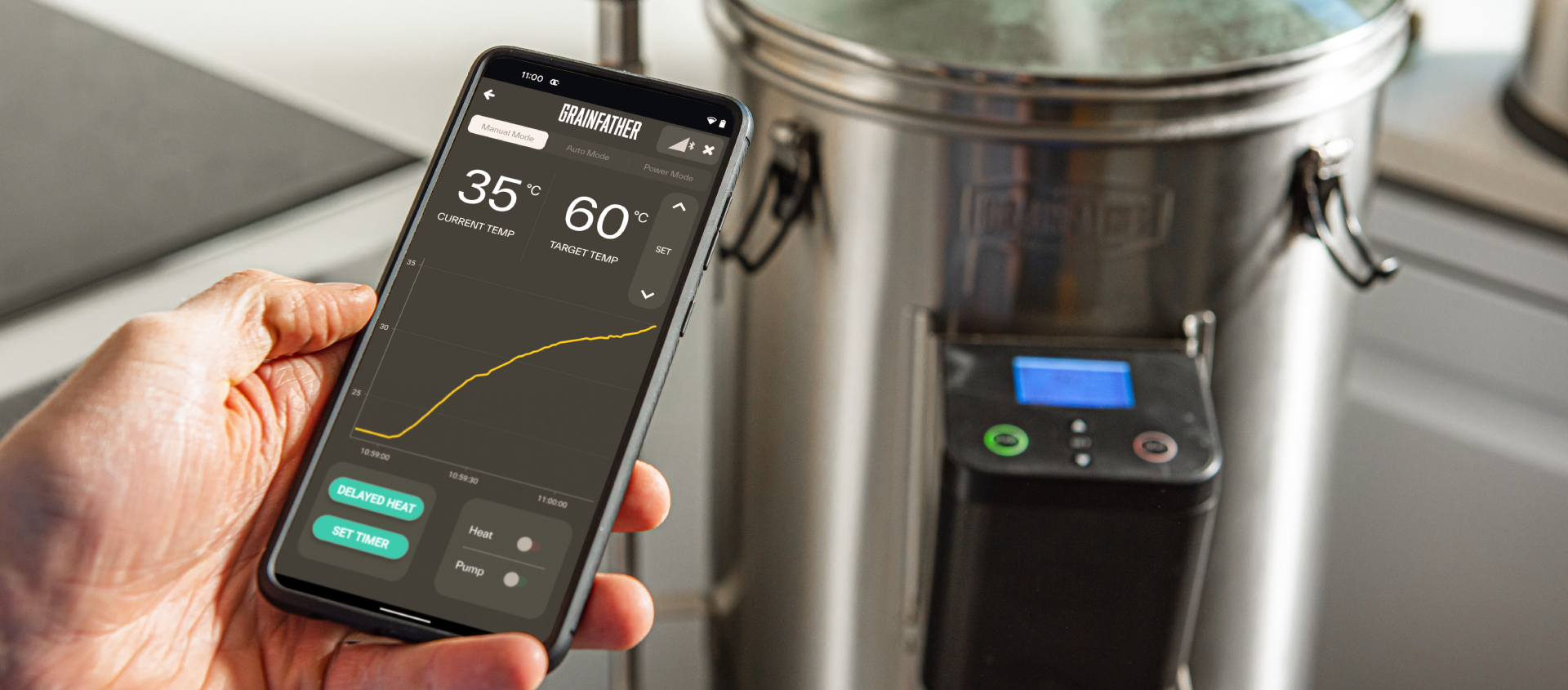 Hand Holding Mobile Phone with Grainfather Brewing App Next to G30 Brewing System